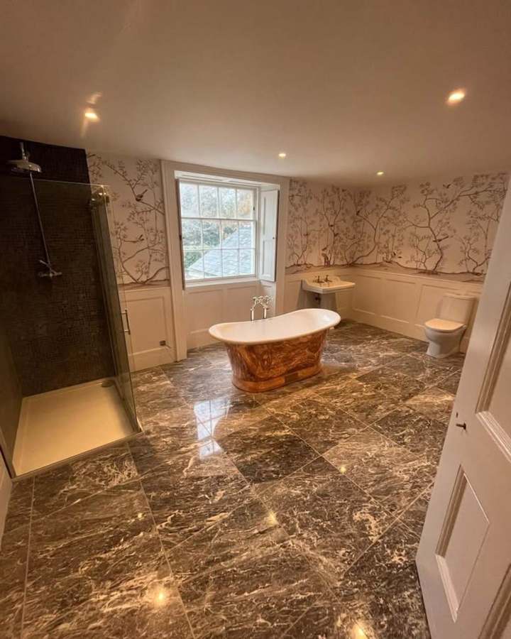Copper freestanding bath on marble floor — SWW showpiece install